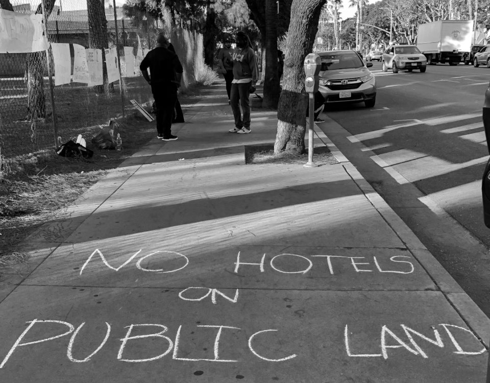 "no hotels on public land" written in sidewalk chalk black and white photograph
